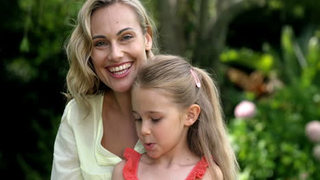 Portrait-of-cute-mother-and-daughter-are-looking-the-camera-and-smiling