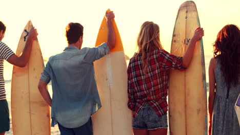 Happy-friends-holding-surfboards