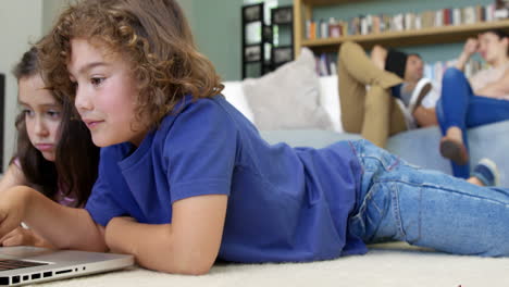 Two-children-are-using-computer-while-adults-are-talking