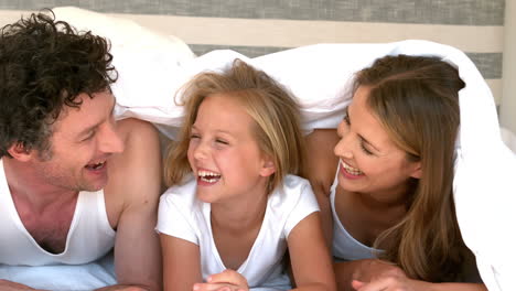 Cute-family-hiding-on-their-bed