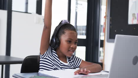 In-a-school-classroom,-a-young-African-American-girl-raises-her-hand