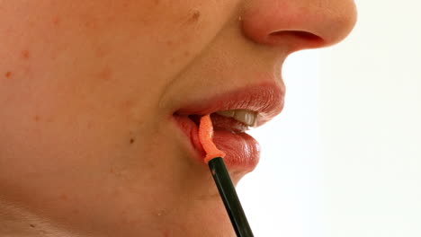 Woman-putting-on-lip-gloss