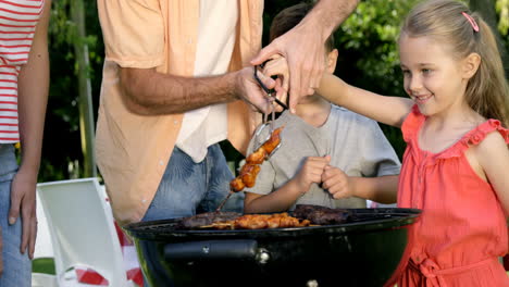 Close-up-on-happy-family-is-eating-a-barbecue-in-the-garden