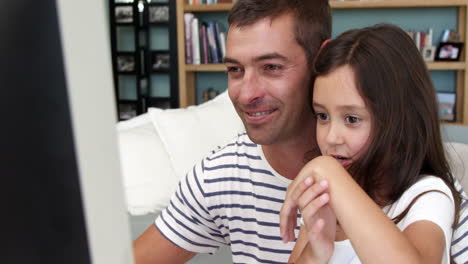 Happy-father-and-daughter-doing-a-video-conference-via-a-computer