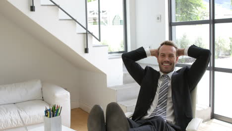 Businessman-smiling-and-relaxing-on-a-chair