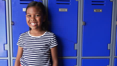 In-a-school-hallway,-a-young-biracial-girl-stands-confidently-with-copy-space
