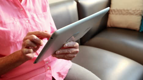 Close-up-view-of-retired-woman-playing-with-tablet-computer