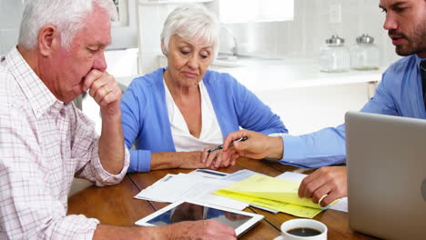 Pareja-Madura-Llenando-Algunos-Documentos-Formales-Con-El-Hombre