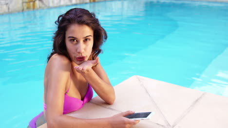 Pretty-woman-relaxing-on-pool-and-giving-a-kiss