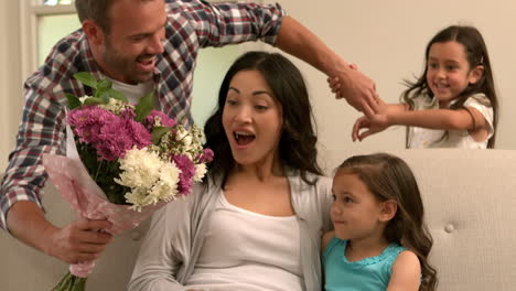 Father-and-daughter-giving-bouquet-to-mother