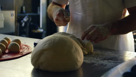 Chef-spreading-flour-on-dough-in-kitchen-4k