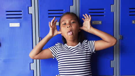 In-a-school-hallway,-a-young-biracial-girl-makes-a-playful-face