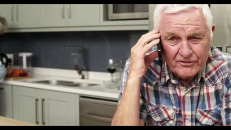Älterer-Mann-Am-Telefon-In-Der-Küche