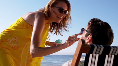 Woman-applying-sunscreen-on-the-nose-of-a-man