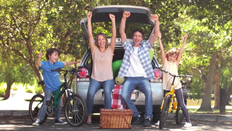 Happy-family-in-front-of-a-car-with-bike