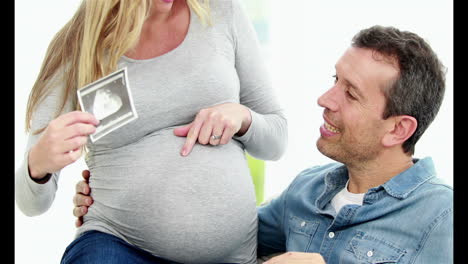 Smiling-pregnant-woman-sitting-on-her-husband