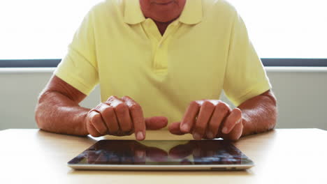 Close-up-view-of-senior-man-using-tablet-computer