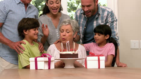 Cute-grandmother-blowing-her-candles-with-her-family