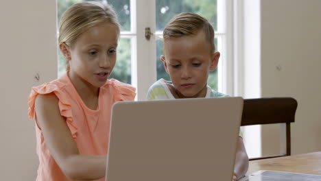 Dos-Niños-Usando-Una-Computadora-Portátil-Con-Su-Madre