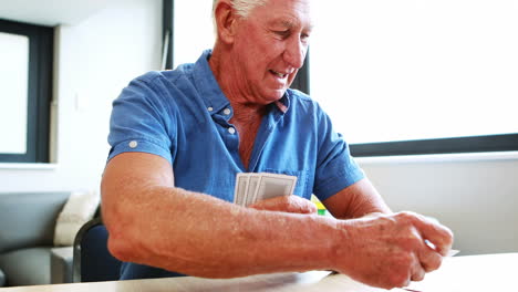 Retired-man-playing-with-cards-