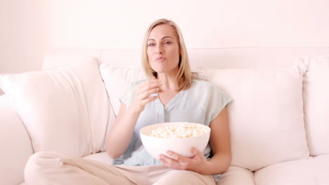 Blonde-Frau-Sitzt-Auf-Einem-Sofa-Und-Isst-Popcorn