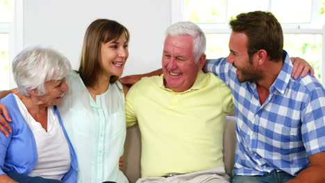 Family-holding-each-other-and-smiling-on-a-sofa