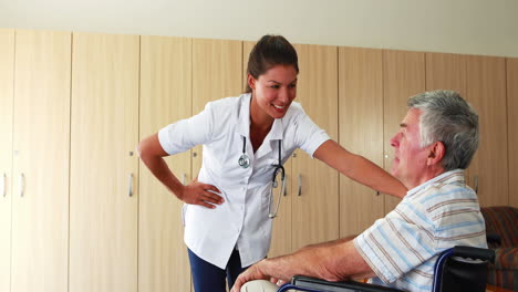 Nurse-speaking-with-a-senior-man-sitting-on-his-wheelchair