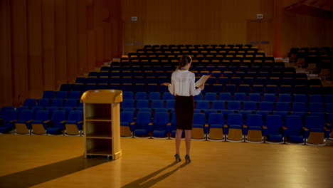 Young-Caucasian-businesswoman-practicing-speech-in-empty-auditorium-4k