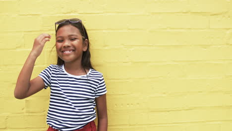 En-La-Escuela,-Una-Joven-Birracial-Se-Ríe-Sobre-Un-Fondo-Amarillo-Con-Espacio-Para-Copiar