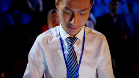 Young-Asian-businessman-using-digital-tablet-during-business-seminar-in-auditorium-4k