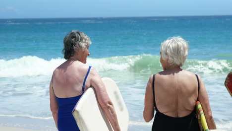 Senior-woman-holding-surfboard