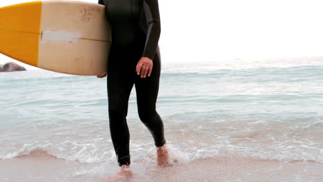Senior-woman-running-with-surfboard