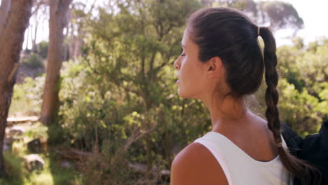 Woman-standing-with-a-backpack-at-campsite