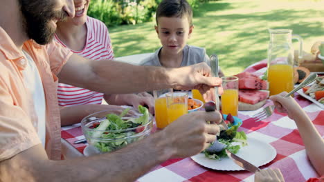 Glückliche-Familie-Isst-Zusammen-Im-Garten