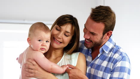 Happy-father-and-daughter-holding-their-baby