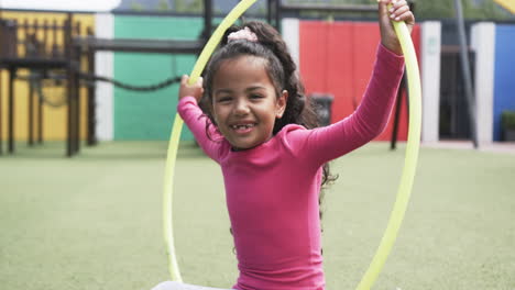 Auf-Einem-Schulhof-Lächelt-Ein-Junges-Afroamerikanisches-Mädchen-Mit-Einem-Hula-Hoop-Reifen