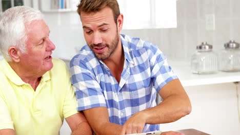 Mature-man-and-man-laughing-in-front-of-a-tablet