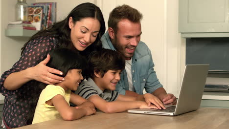 Glückliche-Familie,-Die-Zusammen-Laptop-In-Der-Küche-Benutzt