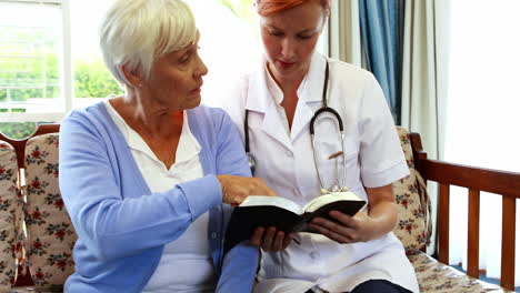 Senior-woman-and-nurse-reading-a-book-together