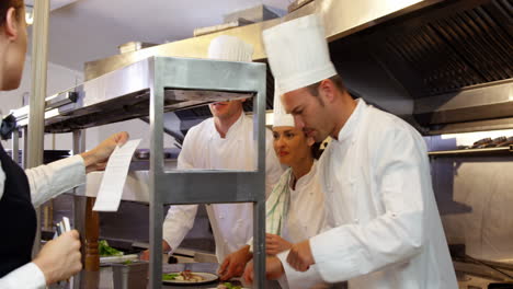 Grupo-De-Chefs-Dando-El-Toque-Final-Y-Dándole-El-Plato-A-La-Camarera