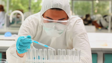 Scientist-pouring-liquid-in-test-tubes