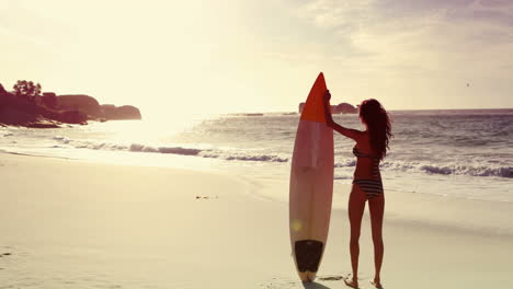 Happy-brunette-holding-surfboard