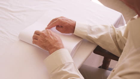 Senior-blind-man-reading-a-braille-book