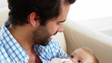 Close-up-of-happy-father-bottle-feeding-to-his-baby