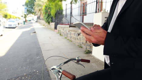 Hombre-De-Negocios-Usando-Un-Teléfono-Inteligente-En-Su-Bicicleta