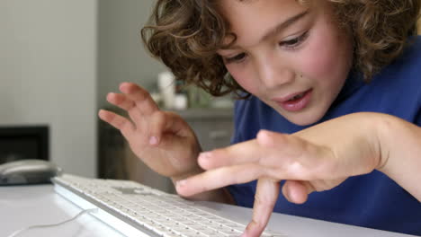 Boy-typing-on-a-white-keyboard