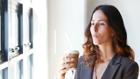 Mujer-De-Negocios-Tomando-Un-Café-Junto-A-La-Ventana