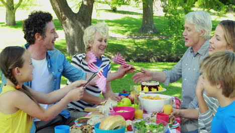 -Family-having-picnic-and-holding-american-flag