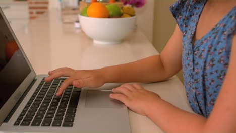 Linda-Chica-Usando-Laptop-En-La-Cocina
