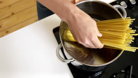 Man-cooking-pasta-in-saucepan